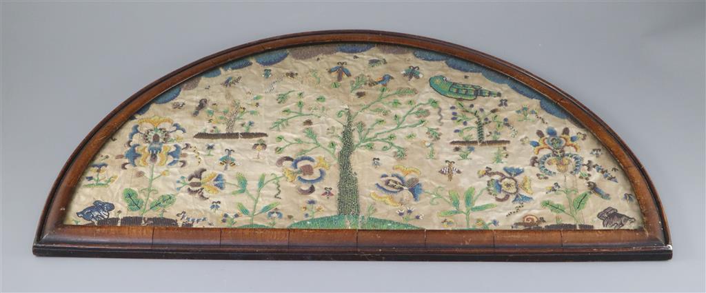 A late 17th century silk and bead work arched panel, width 22.5in. height 11.75in.